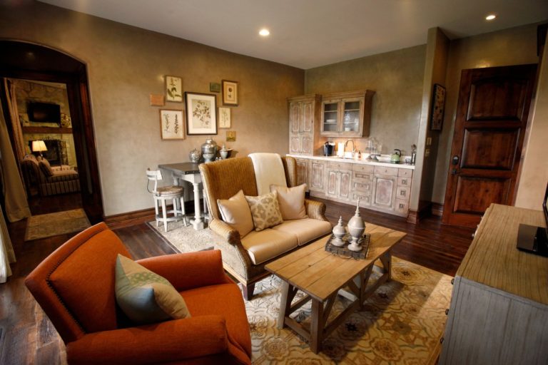 Living area with stuffed chairs, coffee table and kitchenette